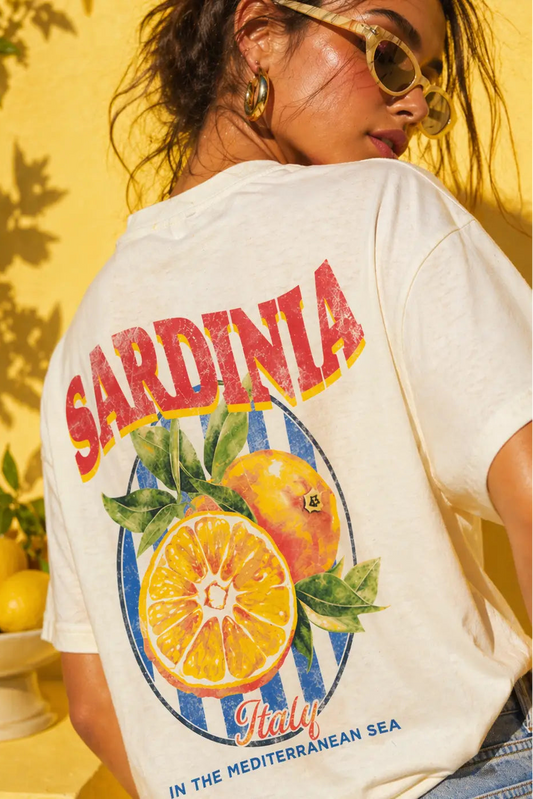 Person wearing a t-shirt with 'Sardinia, Italy' and fruit design against a yellow background.