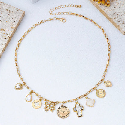 Gold necklace with various charms on a light background