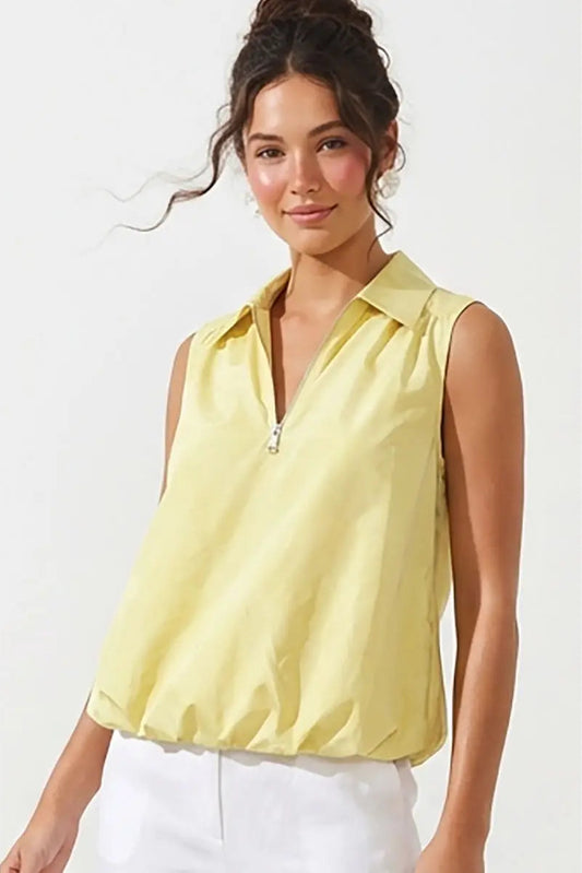 Woman wearing a yellow sleeveless top with a zipper on a white background