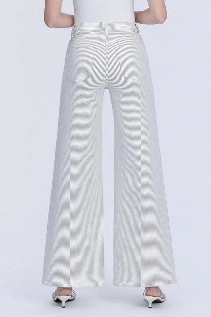 A person shown from the back wearing light gray wide-leg pants with subtle vertical pinstripes, paired with a white top and metallic heels, against a plain light gray studio background.