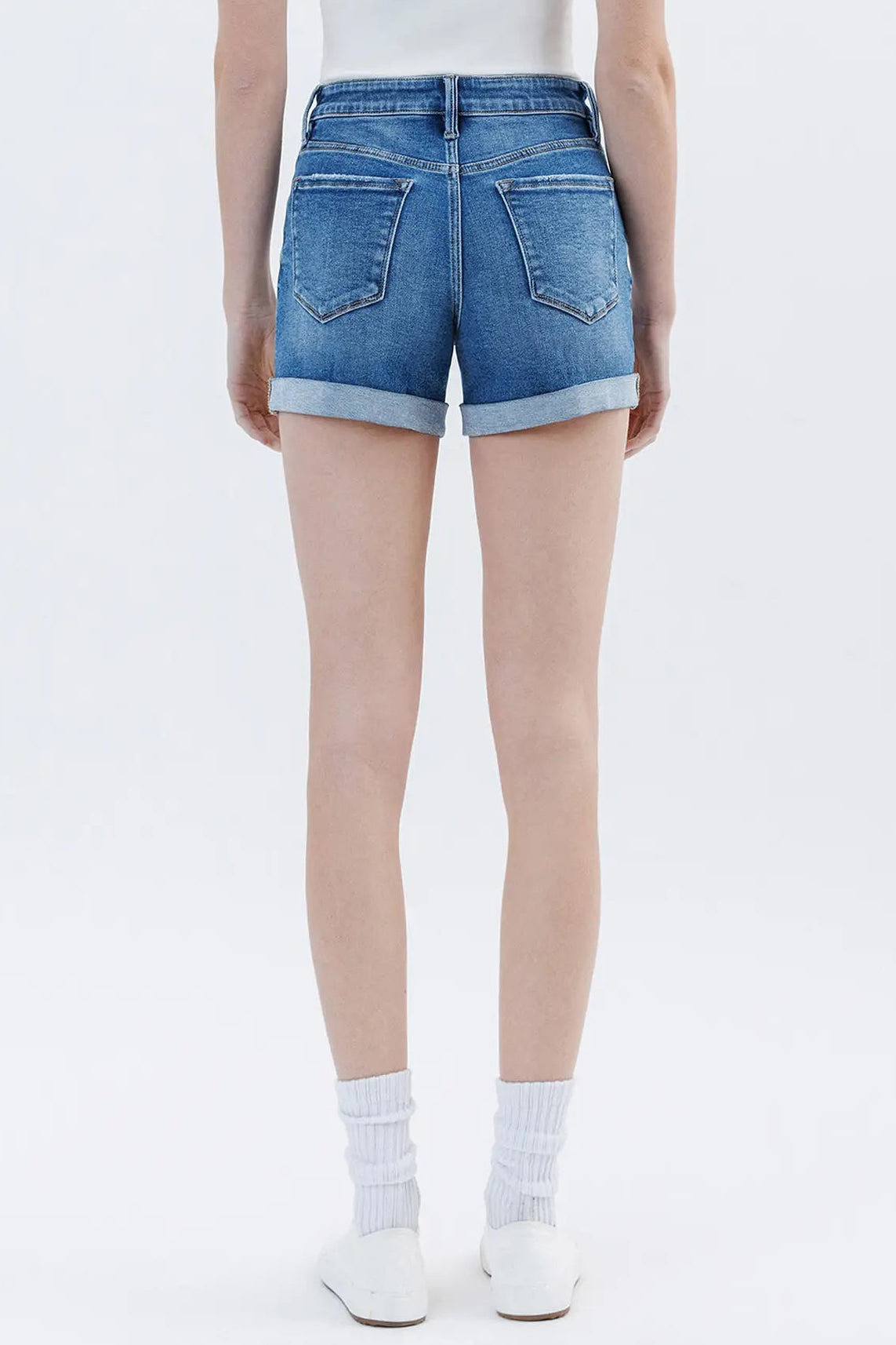 Person wearing blue denim shorts on a white background
