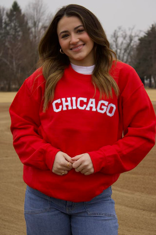 Person wearing a red 'Chicago' sweatshirt in an outdoor setting