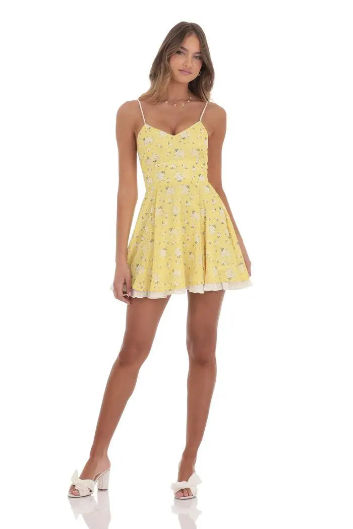 Woman wearing a yellow floral dress on a white background