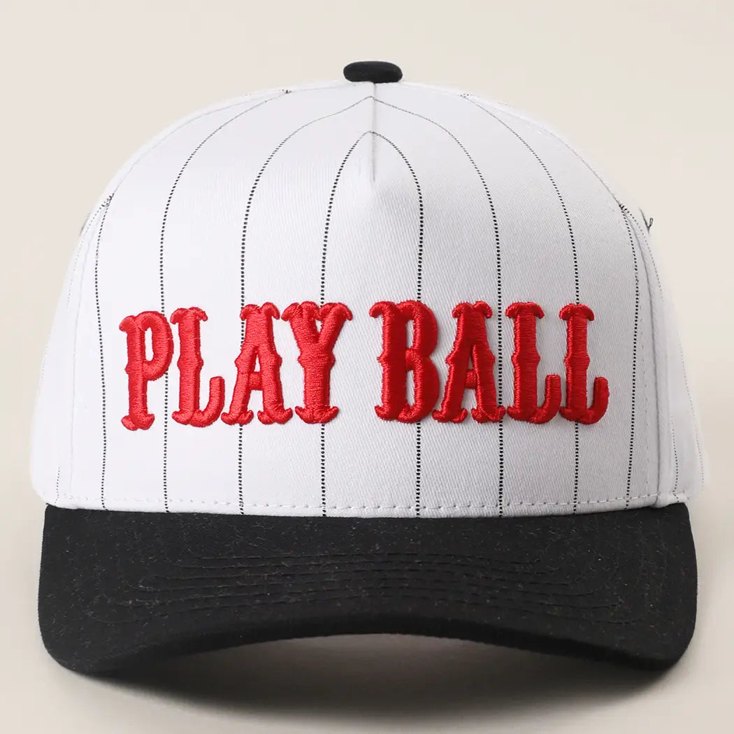 Baseball cap with 'PLAY BALL' text on a beige background
