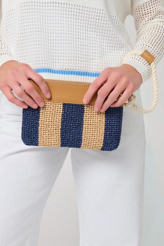 Person holding a striped clutch bag with a neutral background