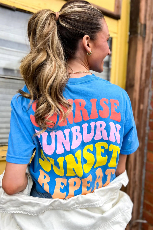 Person wearing a blue t-shirt with colorful text in an urban setting