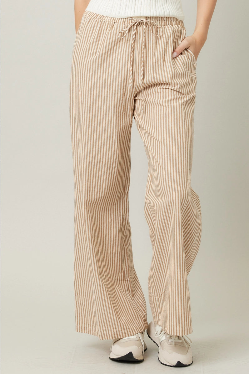 Beige striped pants worn by a person on a plain background