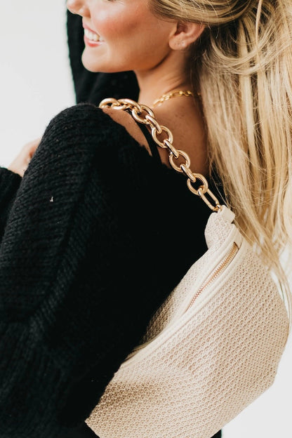 person with gold chain purse