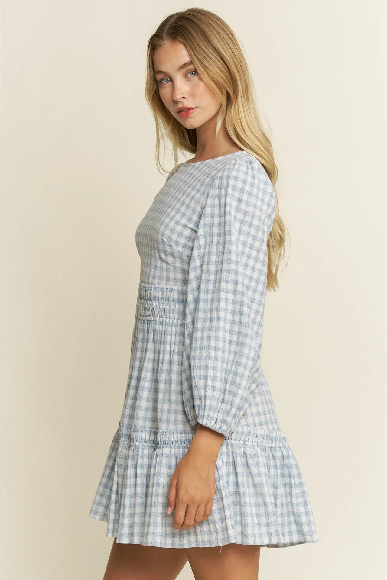Woman wearing a checkered dress on a beige background