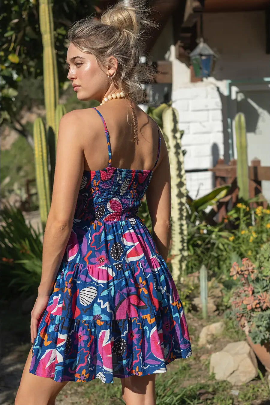 Woman wearing a colorful dress with a garden background
