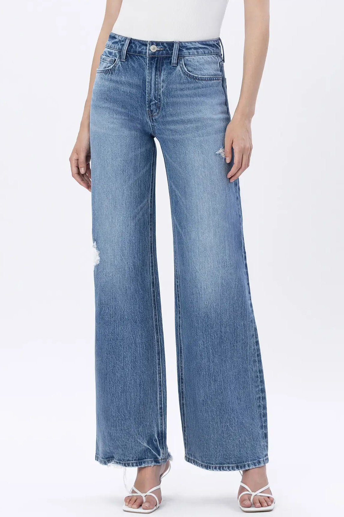 Person wearing light blue wide-leg jeans on a white background