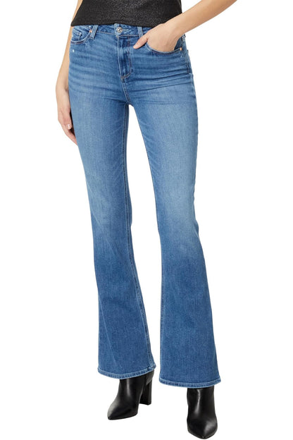 Blue flared jeans worn by a person on a white background