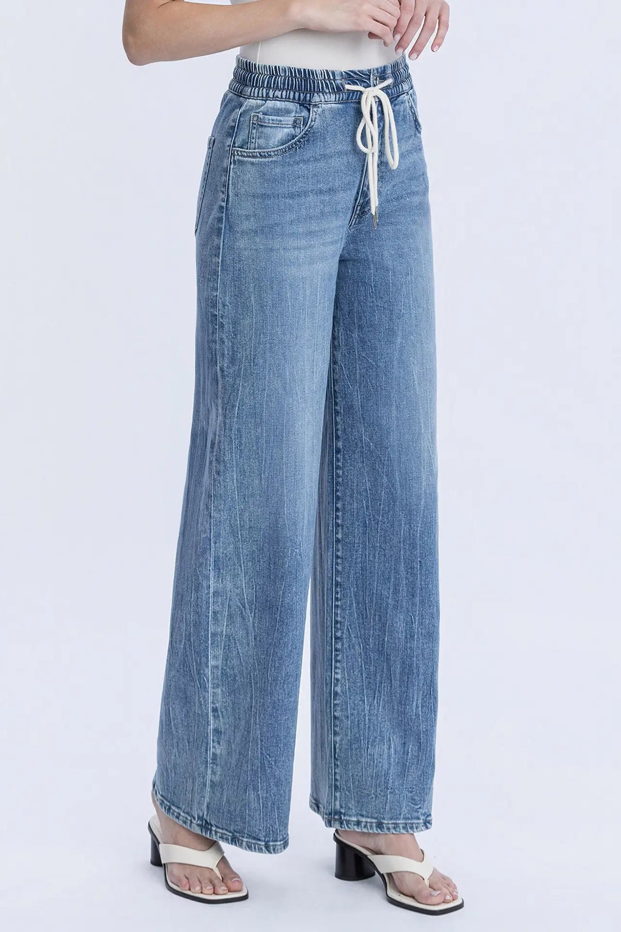 Wide-leg jeans with a drawstring waist on a white background