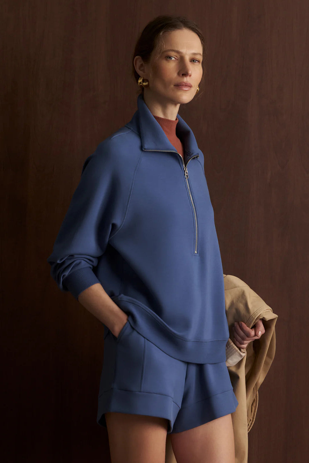 Woman wearing a blue outfit against a brown background
