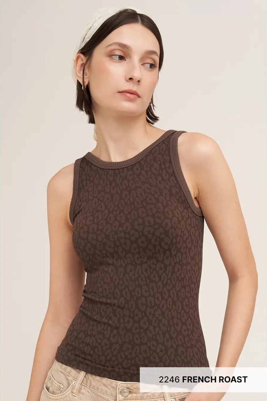 A woman wearing a dark brown ribbed tank top with a subtle tonal animal print pattern, paired with light beige jeans and a white headband. A text overlay at the bottom right reads '2246 FRENCH ROAST'.