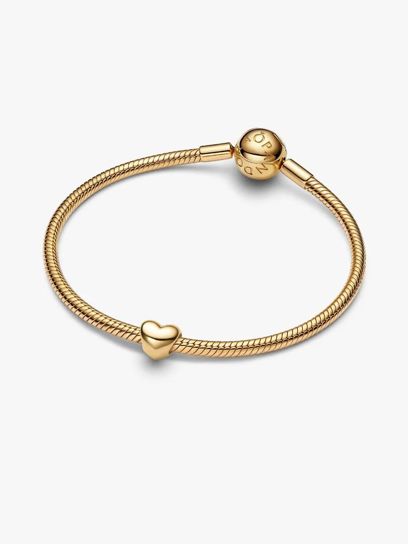 Gold bracelet with a heart-shaped charm on a white background