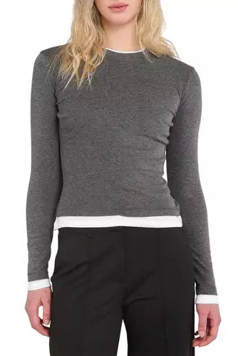 A woman wearing a dark gray long-sleeve crewneck sweater with contrasting white trim at the collar, hem, and cuffs, paired with black pants against a plain white background.