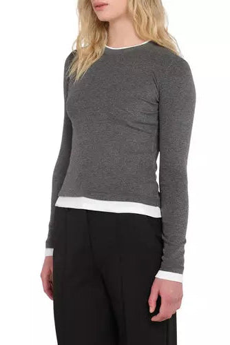 A woman wearing a dark gray long-sleeve crewneck sweater with white contrast trim at the collar, hem, and cuffs, paired with black pants, shown against a plain white background.