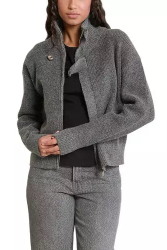 A woman wearing a gray ribbed knit zip-front jacket with a high stand collar, styled over a black top and paired with matching gray textured pants, shown against a plain white background.