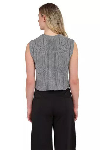 A woman shown from the back wearing a gray sleeveless cable-knit cropped sweater vest and black wide-leg trousers, against a plain white background.