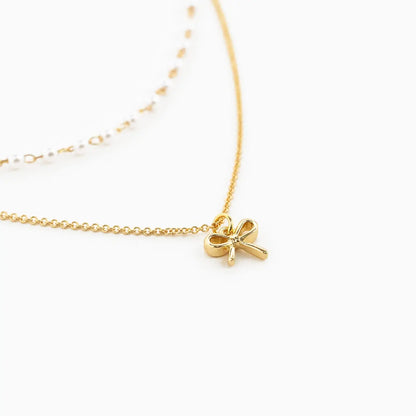 Double Layered Pearl Chain and Bow Pendant Necklace on white background