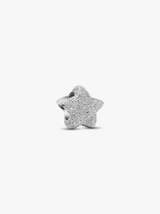 Silver star-shaped charm on a white background