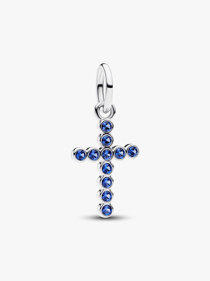 Silver cross pendant with blue gemstones on a white background
