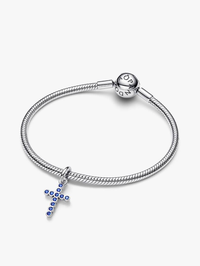 Silver bracelet with a cross charm on a white background