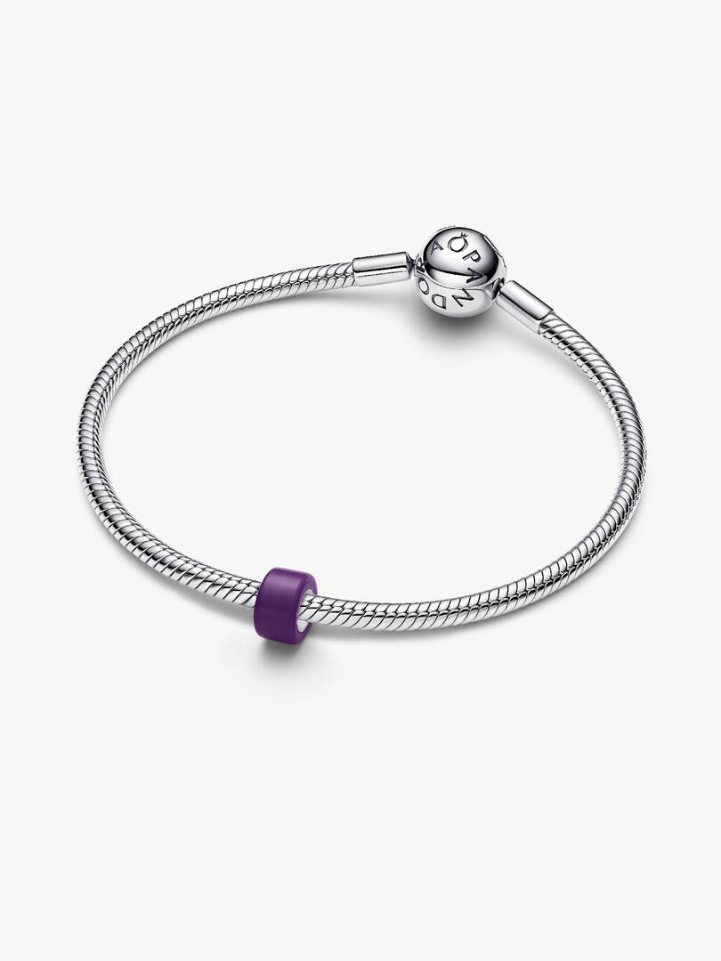 A silver-toned snake chain bracelet with a heart charm engraved with 'PANDORA' and a small purple accent bead, shown on a light gray background.
