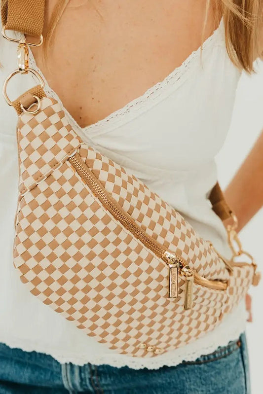 Person wearing a beige checkered sling bag with gold accents