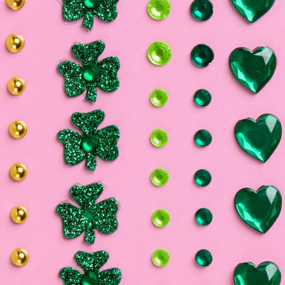 Green glitter shamrocks and hearts on a pink background with gold accents.