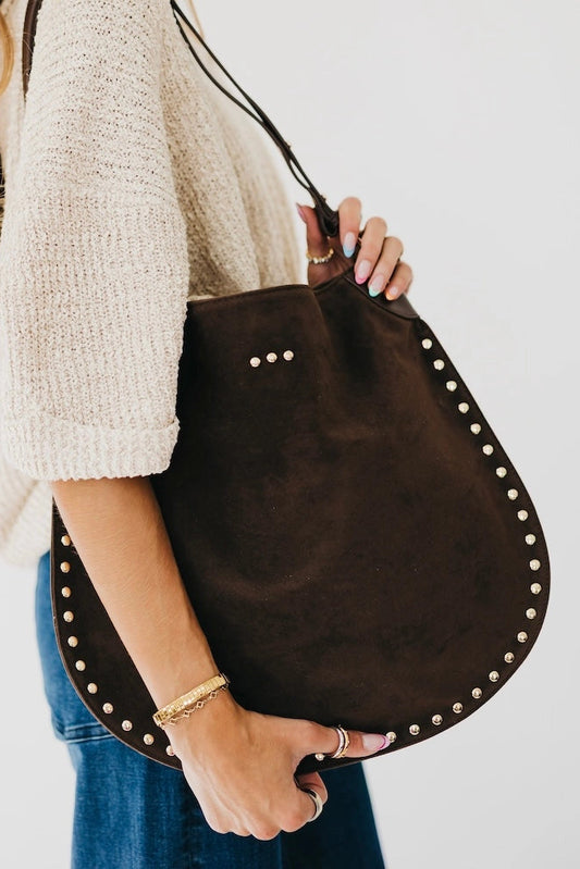 person holding brown hobo bag