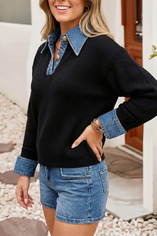 A woman wearing a black long-sleeve knit sweater with a blue denim collar and turned-up cuffs, paired with blue denim shorts, standing outdoors in front of a doorway.