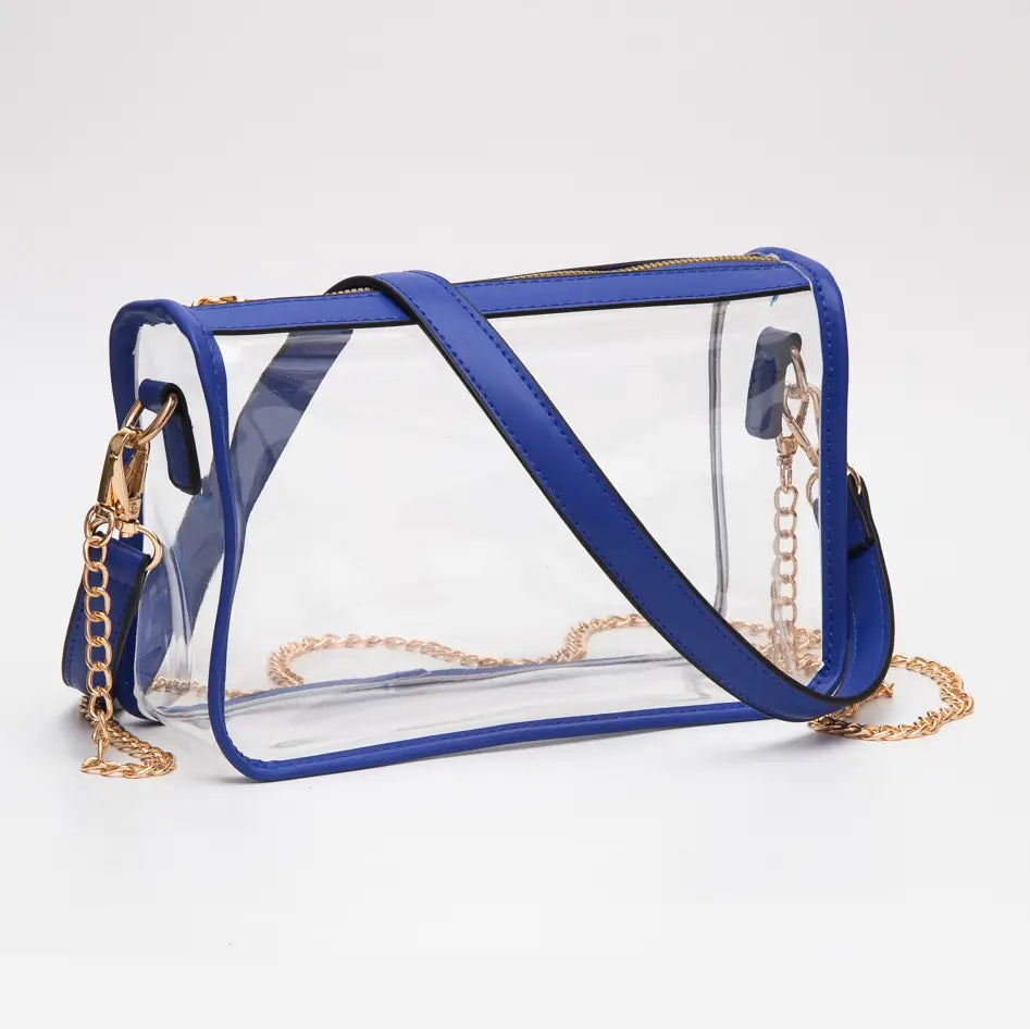 Clear handbag with blue accents and gold chains on a white background
