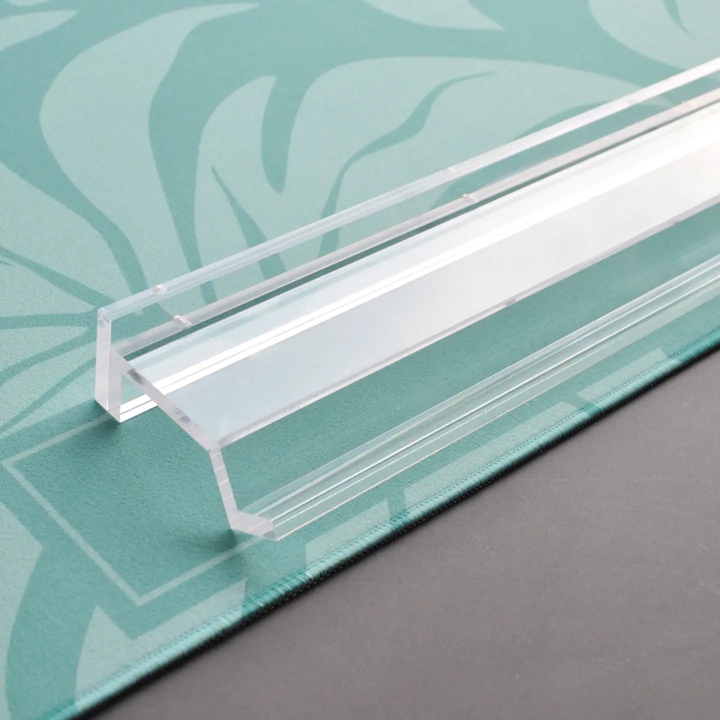 Clear plastic strip on a green leaf-patterned surface