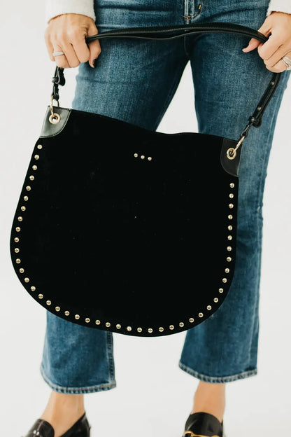 person holding black hobo bag