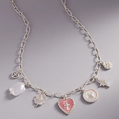 Silver necklace with various charms on a gray background