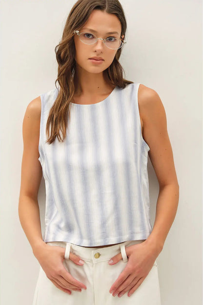 Woman wearing a sleeveless striped top against a plain background
