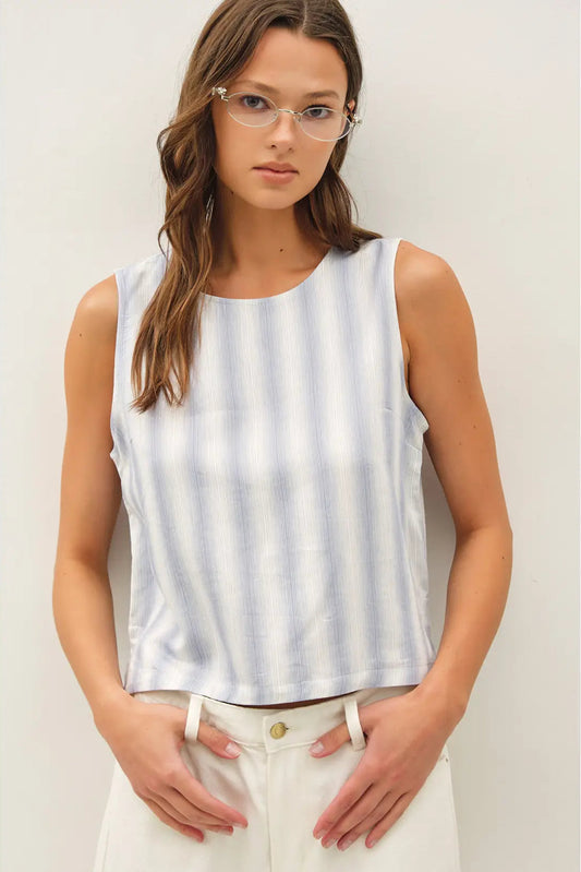 Woman wearing a sleeveless striped top against a plain background