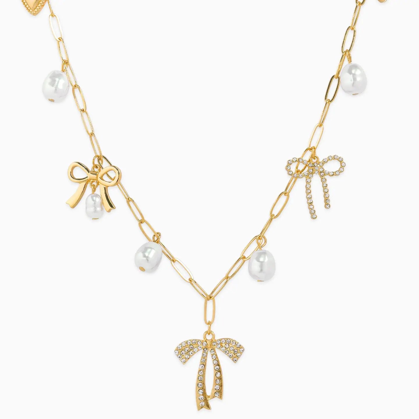 Gold necklace with bow and pearl pendants on a white background