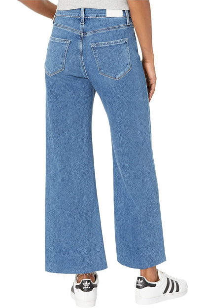 Blue jeans worn by a person on a white background