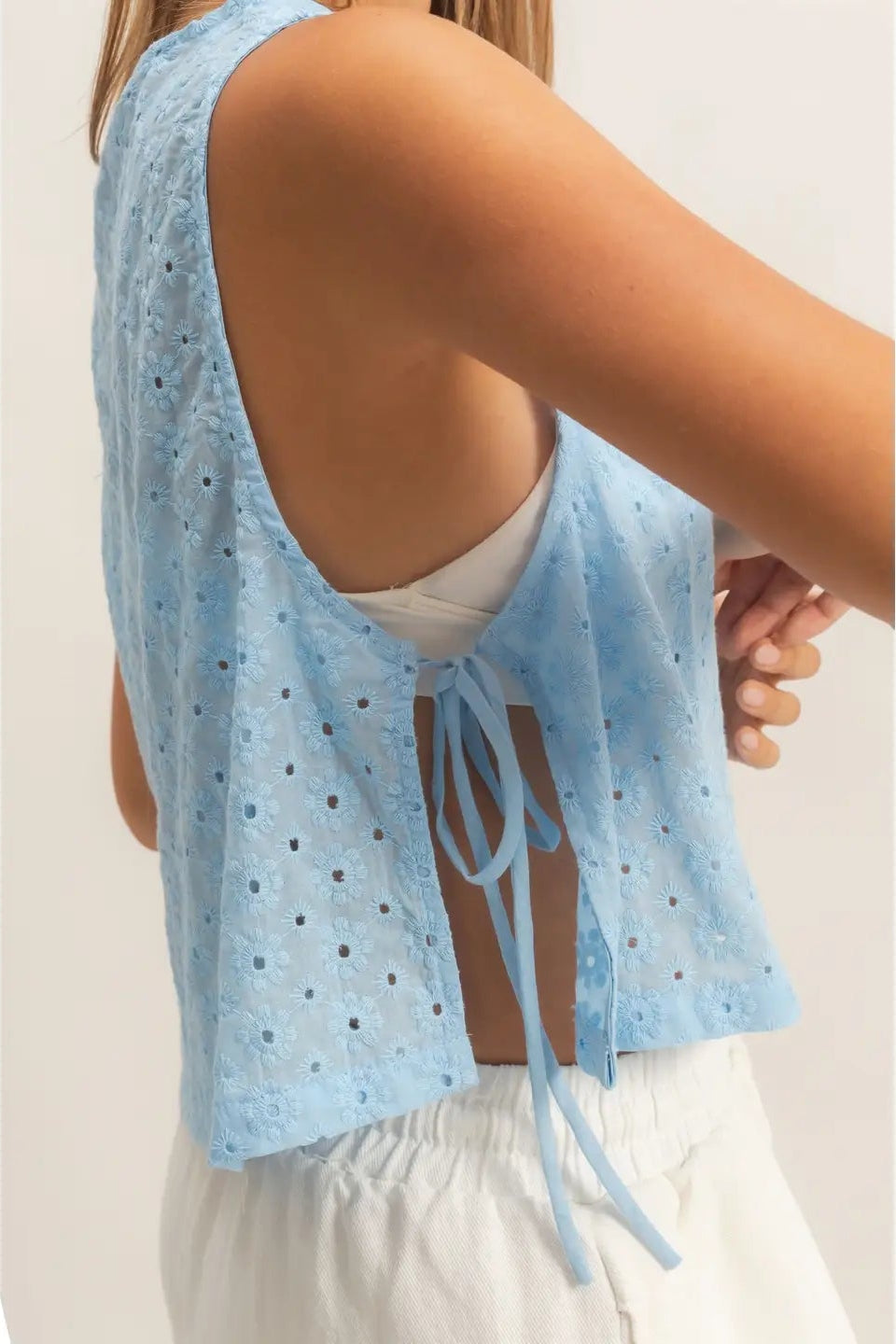 Light blue sleeveless top with lace details worn by a person on a plain background