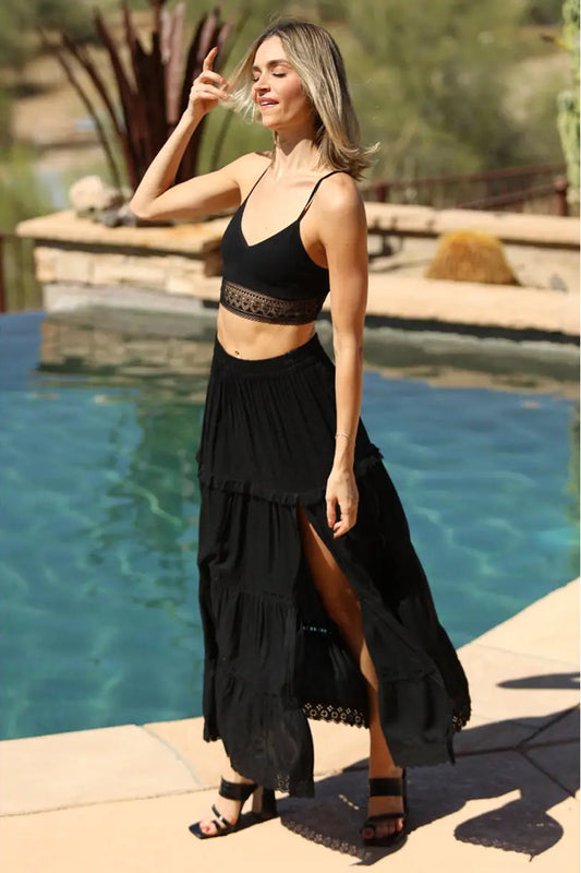Woman in black outfit standing by a pool