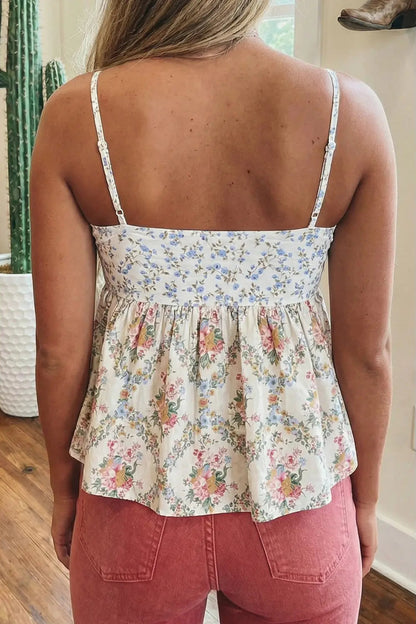 Woman wearing a floral top and pink pants indoors.