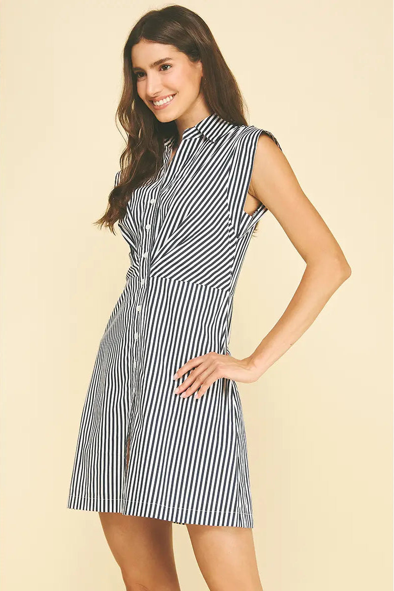 Woman wearing a black and white striped dress on a beige background