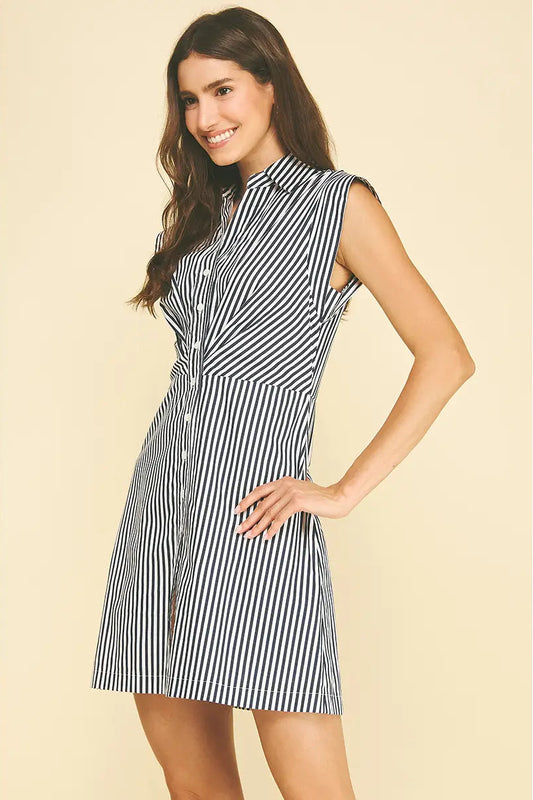 Woman wearing a black and white striped dress on a beige background