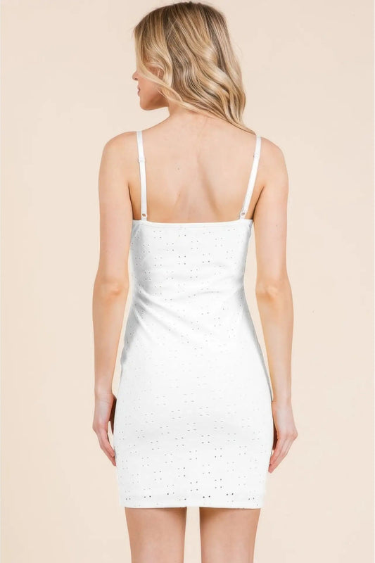 Woman wearing a white dress with thin straps on a beige background