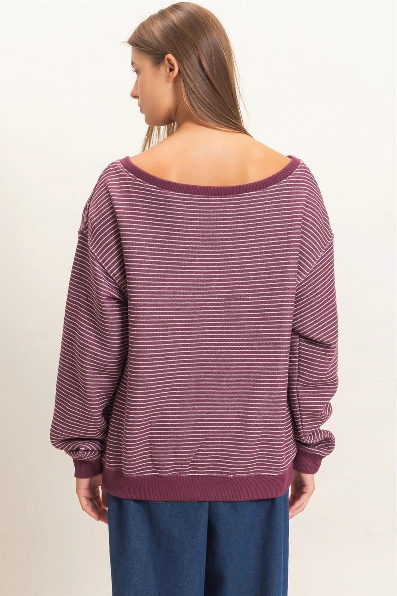 Woman wearing a purple striped sweater and blue pants on a white background