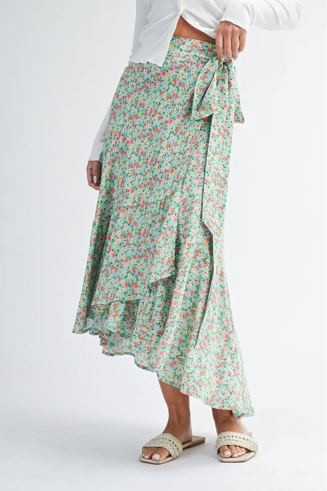 Green floral skirt worn by a person on a white background