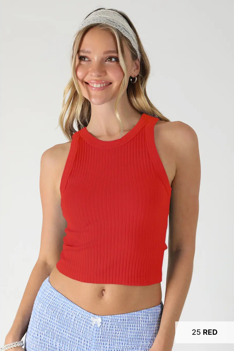 Woman wearing a red sleeveless top with a plain background